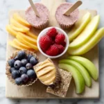 A variety of healthy after school snacks like fruits, nuts, and yogurt