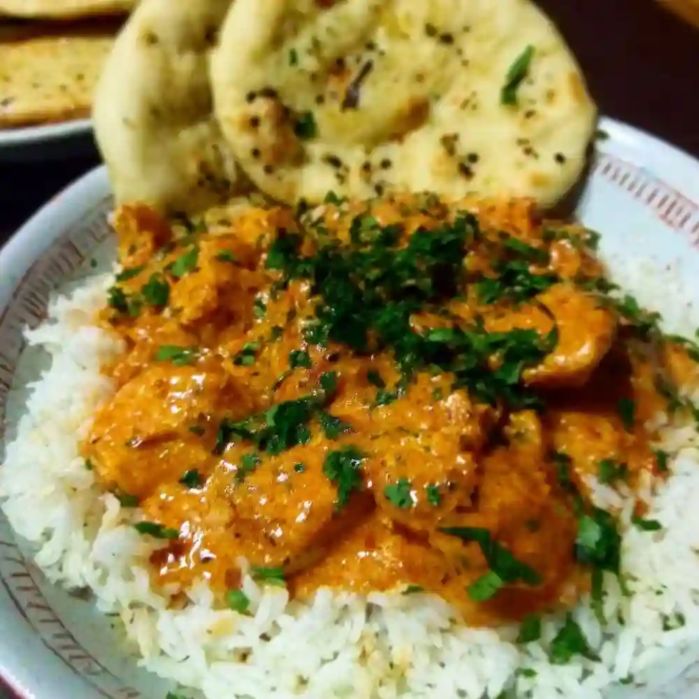 Delicious homemade butter chicken served with rice and naan bread.
