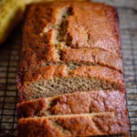 Delicious slice of moist banana bread on a wooden cutting board