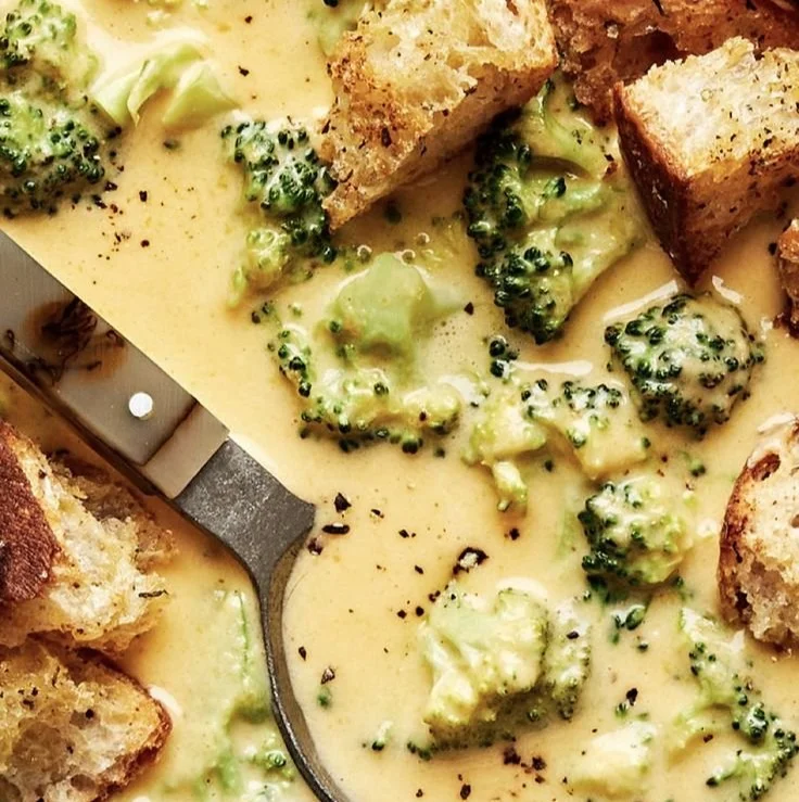A bowl of creamy Broccoli Cheddar Soup garnished with fresh broccoli florets