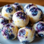 Lemon Blueberry Cottage Cheese Protein Bites on a plate with fresh berries
