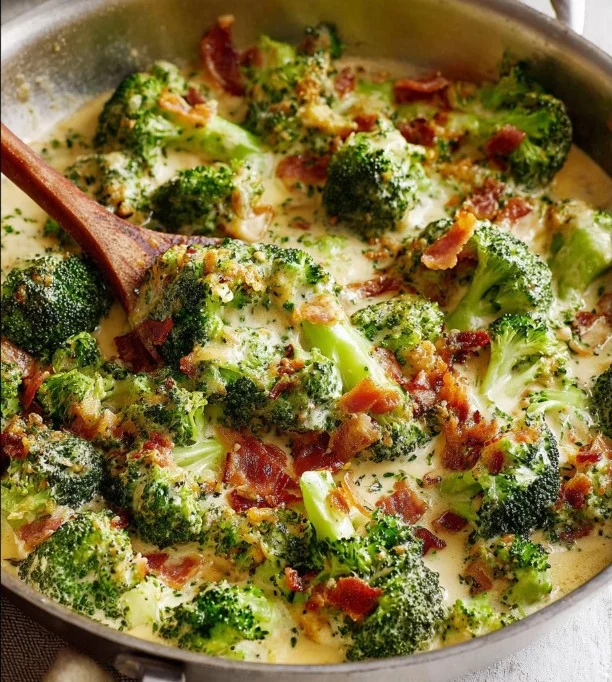 Creamy garlic parmesan broccoli topped with crispy bacon in a serving dish