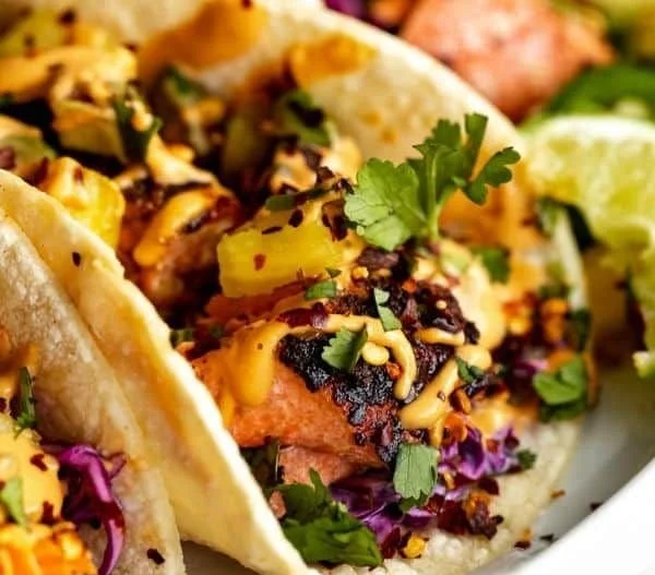 Crispy salmon tacos topped with fresh ingredients and served in a tortilla