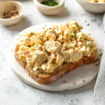 Healthy tuna egg salad in a bowl garnished with fresh herbs
