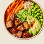 Vegan sushi bowl featuring spicy pan-fried tofu, vegetables, and sushi rice.