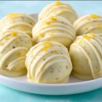 No-bake lemon truffles on a plate garnished with lemon zest.