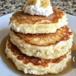 Fluffy banana pancakes made with cottage cheese topped with fresh banana slices