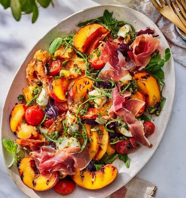 Grilled nectarine burrata salad with prosciutto on a plate