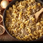 A hearty serving of Ground Beef Stroganoff topped with herbs and served on a plate.
