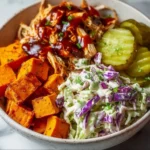 Delicious BBQ chicken bowl topped with fresh vegetables and sauce