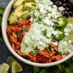 Delicious Chicken Tinga Bowl topped with fresh vegetables and avocado.