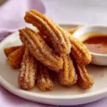 Freshly made churros dusted with sugar and served with chocolate sauce.