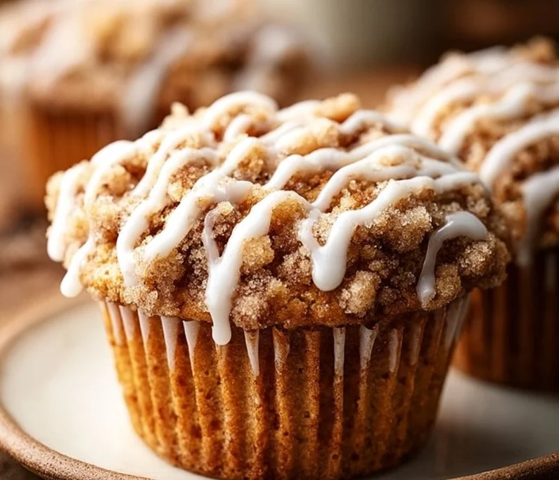 Freshly baked Cinnamon Coffee Cake Muffins on a wooden table.