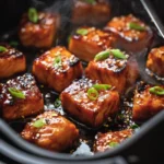 Crispy air fryer salmon bites garnished with herbs on a plate