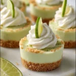 No-bake key lime cheesecake cups topped with whipped cream and lime zest