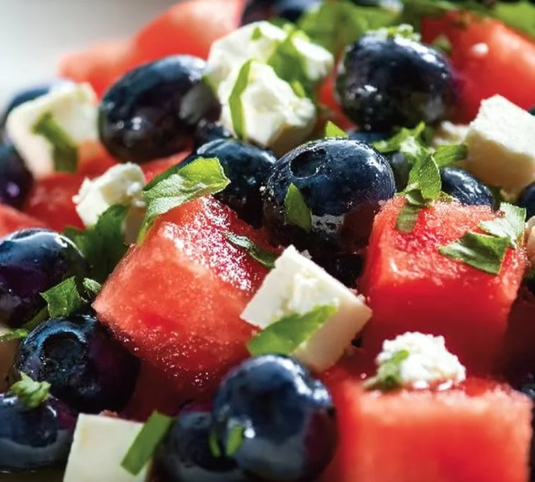 A vibrant watermelon blueberry feta salad in a bowl, showcasing fresh ingredients.