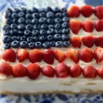 Flag fruit pizza on a sugar cookie crust topped with colorful fruits