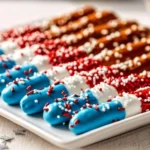 Colorful Fourth of July pretzel rods decorated with red, white, and blue chocolate.